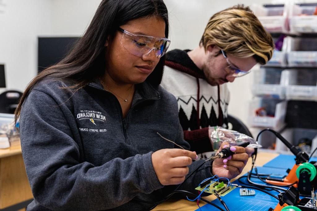 Two students soldering in the Makerspace